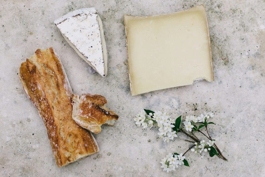 Artisanal Cheese cut, next to a piece of bread