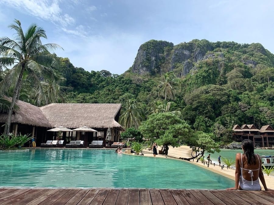 people around the lodge and pool in a tropical private island