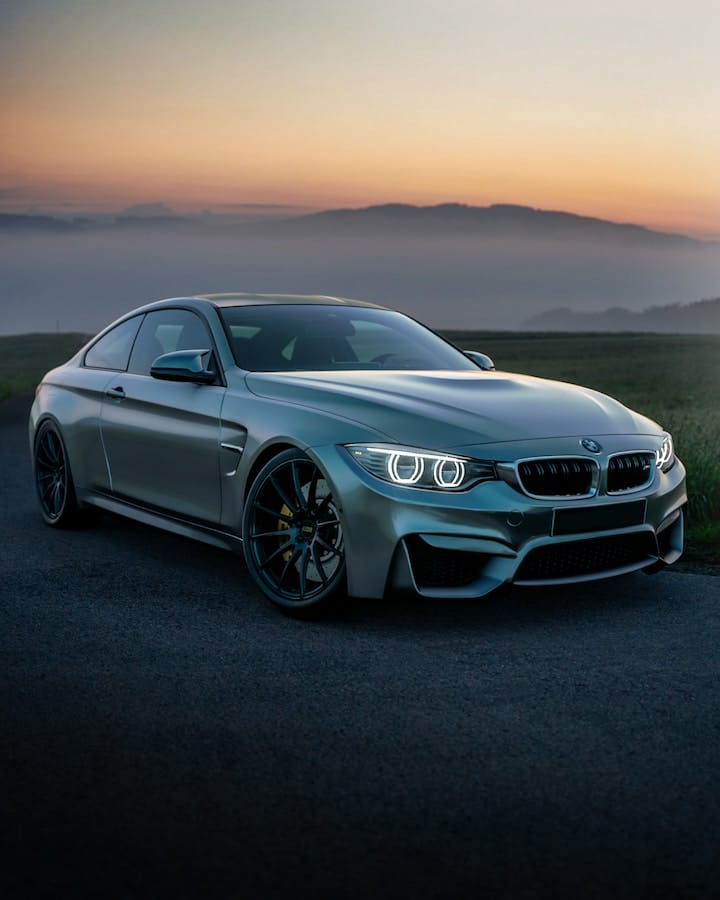 an Ultra-Luxury Car during sunset near a meadow