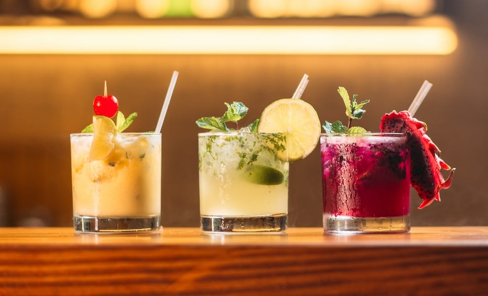 three cocktails next to each other, orange, yellow, and red