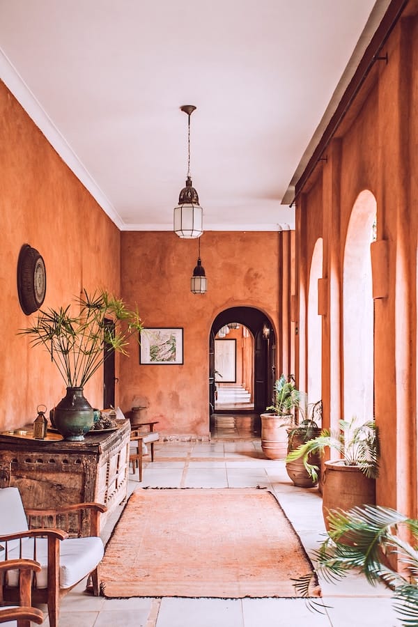 a hallway and reddish walls, demonstrating High-End Interior Design