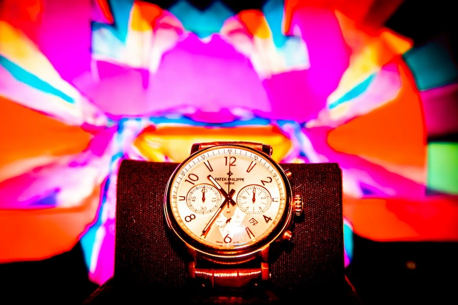 closeup shot of a luxury watch in display, with colors in the background